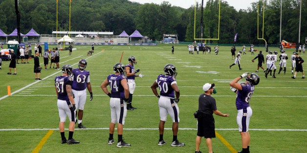 Members of the Baltimore Ravens prepare to run drills at the team's first day of NFL football training camp, Thursday, July 3