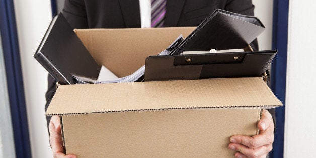 Portrait of young businessman holding cardboard in office