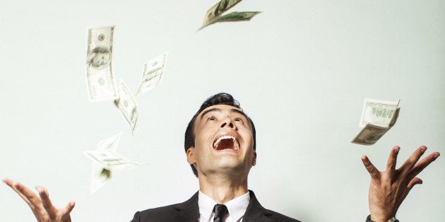 Businessman rejoicing for his success with hundred dollar bills. Money rain concept.