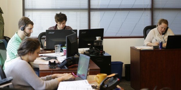 Sales representatives work Wednesday, April 15, 2015, at Gravity Payments, a credit card payment processor based in Seattle. Gravity CEO Dan Price told his employees this week that he was cutting his roughly $1 million salary and using company profits so they would each earn a base salary of $70,000, to be phased in over three years. (AP Photo/Ted S. Warren)