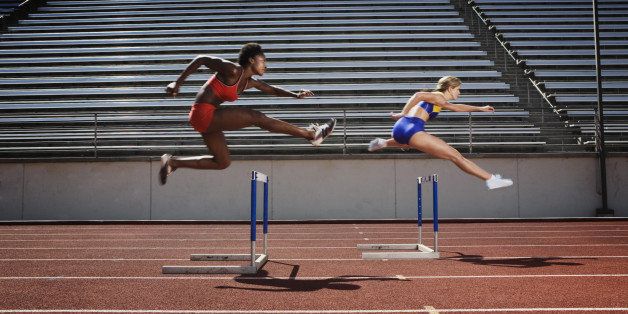 Women jumping over hurdles