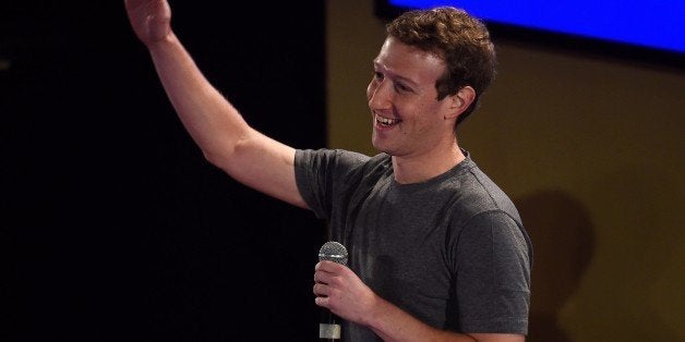 Facebook chief executive and founder Mark Zuckerberg waves to the crowd as he arrives for a 'town-hall' meeting at the Indian