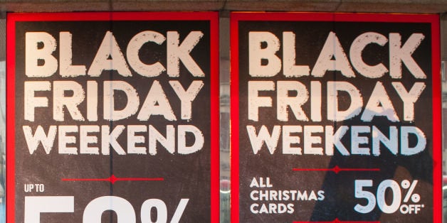 Embargoed to 0001 Tuesday December 9 File photo dated 28/11/14 of people walking past posters advertising 'Black Friday' sale