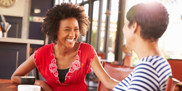 Two female friends talking at a coffee shop