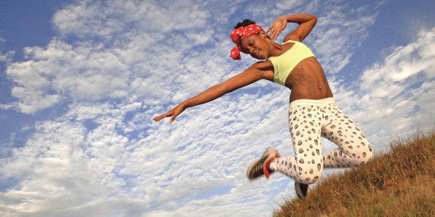 Full length an ecstatic African American female jumping in excitement.