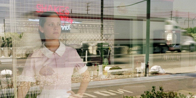 Waitress in diner looking out window