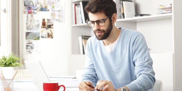 Young small business owner sitting at desk and working at home.