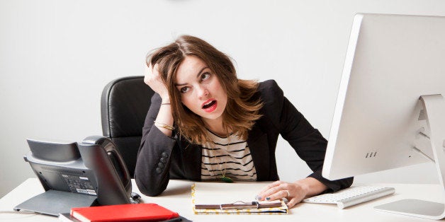 Studio shot of young woman working in office being under emotional stress