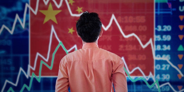 Young male broker looking at a stock market of china with declining arrows