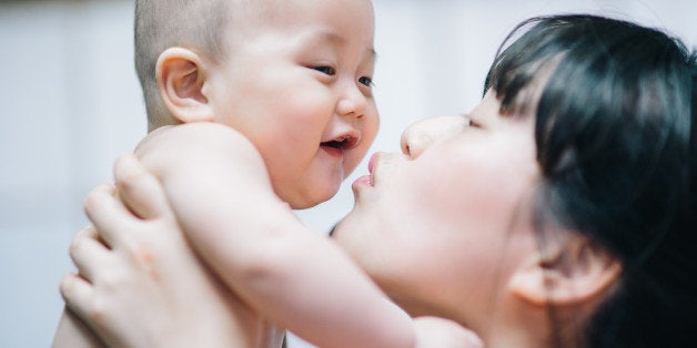 Mother holds and kisses her baby