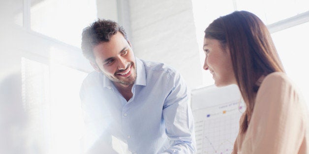 Smiling businessman and businesswoman in conference room