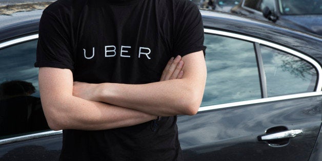 A protester wears a shirt displaying the logo of smartphone ride service Uber during by a protest by non-licensed private hire drivers blocking the Place de la Nation in Paris on February 9, 2016.Members of services known in France as 'voitures de tourisme avec chauffeur' (VTC - Tourism vehicle with driver) have been protesting against assurances the French Prime minister has given to taxis. / AFP / Geoffroy Van der Hasselt (Photo credit should read GEOFFROY VAN DER HASSELT/AFP/Getty Images)