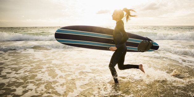 Caucasian surfer carrying board in waves