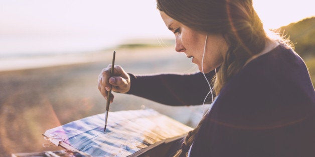 Portrait of painting blondhaired woman at the beach