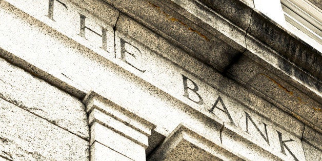 A detail view of the words THE BANK chiseled in stone.