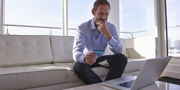 Man using laptop and credit card.