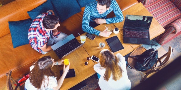 Group of young people sitting at a cafe, top view