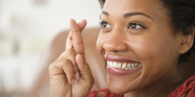 Close up of Black woman smiling with fingers crossed