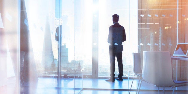 Businessman looking out of office over city