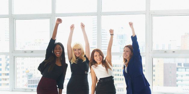 Businesswomen cheering in conference room