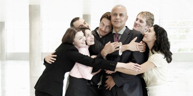 Group of business people hugging one person