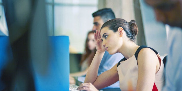 Woman at desk, staring at computer screen