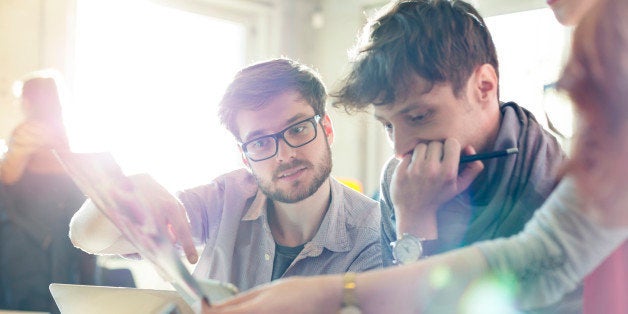 Creative business people reviewing proofs in sunny office