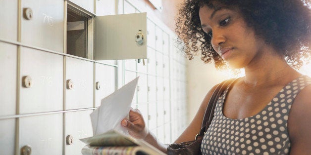 Mixed race businesswoman checking mailbox