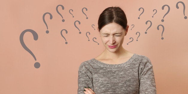 Portrait of young woman with distressed facial expression and a lot questions marks around