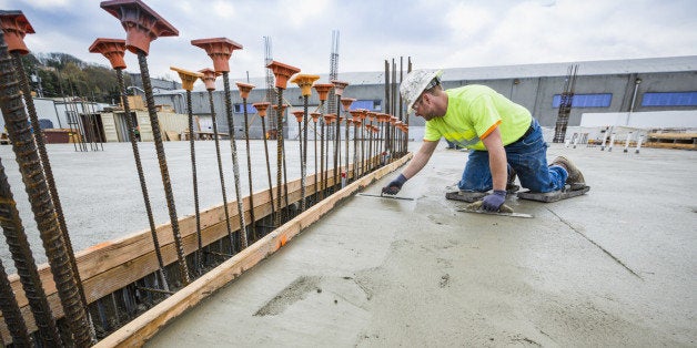 Worker finishing concrete at construction site