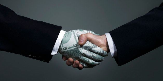 Businessman shaking hands with man made of money
