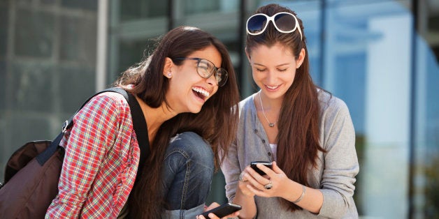 Two female friends using mobile phones