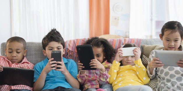 Children using technology on sofa