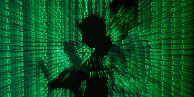 An illustration picture shows a projection of binary code on a man holding a laptop computer, in an office in Warsaw June 24, 2013. REUTERS/Kacper Pempel/Illustration/File Photo