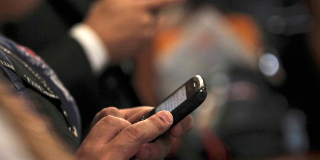 In this photo taken Sept. 14, 2011, a journalist twits in his mobile phone during a news conference in Caracas, Venezuela. Venezuela's political battle is playing out in a new way on Twitter, where the accounts of at least nine critics of President Hugo Chavez have been mysteriously taken over by hackers who post pro-government messages along with insults and threats.(AP Photo/Fernando Llano)