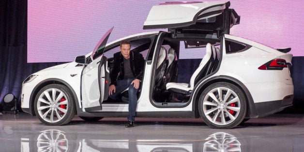 Elon Musk, chairman and chief executive officer of Tesla Motors Inc., exits the Model X sport utility vehicle (SUV) during an event in Fremont, California, U.S., on Tuesday, Sept. 29, 2015. Musk handed over the first six Model X SUVs to owners in California Tuesday night, as Tesla reached a milestone of having two all-electric vehicles in production at the same time. Photographer: David Paul Morris/Bloomberg via Getty Images 