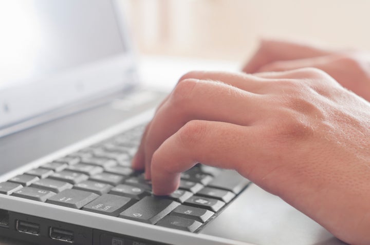 male hands typing on a laptop