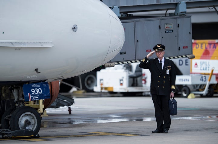 Delta Captain Captain Steven Manley salutes after delivering US War remains during a dignified transfer at Dulles Internation