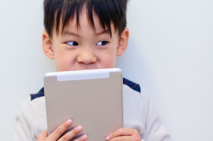Cute little boy holding digital tablet cover the face exposed eyes.