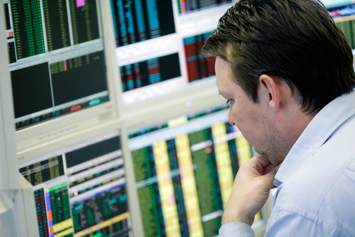 A stockbroker monitors share prices on his computer screens at Shore Capital Group Ltd. brokerage in London, U.K., on Tuesday, March 26, 2013. Cyprus dodged a disorderly default and an unprecedented exit from the euro when the country's lawmakers struck a deal early yesterday with international creditors for the second time in nine days, underscoring the difficulties of crisis management in the region. Photographer: Matthew Lloyd/Bloomberg via Getty Images