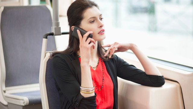 Woman traveling in a bus and talking on a mobile phone