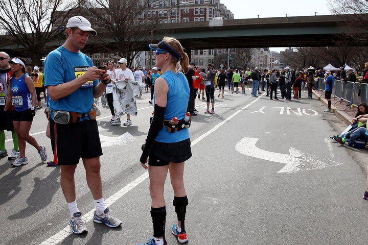 BOSTON, MA - APRIL 15: A runner uses his phone as others gather near Kenmore Square after two bombs exploded during the 117th Boston Marathon on April 15, 2013 in Boston, Massachusetts. Two people are confirmed dead and at least 23 injured after two explosions went off near the finish line to the marathon. (Photo by Alex Trautwig/Getty Images)