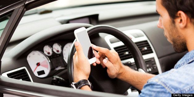 Close up of a young man using smart phone in his car