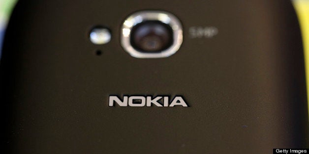 A camera lens and a logo are seen on the reverse side of a Nokia Oyj Lumia 710 smartphone displayed inside a Carphone Warehouse Group Plc store in London, U.K., on Tuesday, Oct. 16, 2012. Nokia is struggling to win back smartphone customers lost to the iPhone, is poking at Apple in social-media and blog postings claiming map superiority, while promoting location features in ads for its latest devices. Photographer: Simon Dawson/Bloomberg via Getty Images