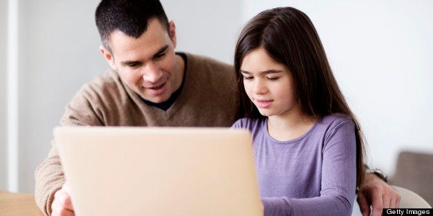 father and daughter using laptop computer