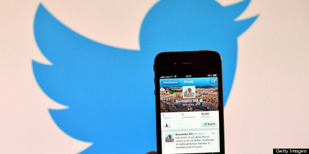 A smartphone showing the first twitter message of Pope Benedict XVI in Italian is held in front of a computer showing the logo of Twitter on December 12, 2012 in Rome. Pope Benedict XVI sent his first Twitter message from a digital tablet on Wednesday during his weekly general audience using the handle @pontifex, blessing his hundreds of thousands of new Internet followers. AFP PHOTO / GABRIEL BOUYS (Photo credit should read GABRIEL BOUYS/AFP/Getty Images)