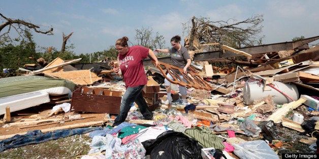 SHAWNEE, OK - MAY 20: Candice Lopez (L) and Stephanie Davis help clean debris from Thelma Cox's mobile home after it was destroyed by a tornado May 20, 2013 near Shawnee, Oklahoma. A series of tornados moved across central Oklahoma May 19, killing two people and injuring at least 21. (Photo by Brett Deering/Getty Images)