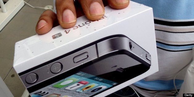 A man holds his new iPhone 4s outside the Apple Store in Washington, DC, October 14, 2011. The launch today was the first since former Apple CEO and co-founder Steve Jobs, 56, passed away October 5, 2011 after a long battle with pancreatic cancer. AFP PHOTO/Jim WATSON (Photo credit should read JIM WATSON/AFP/Getty Images)