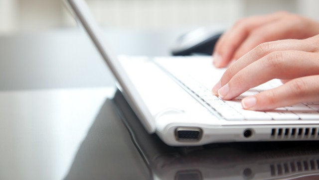 Female hands typing on a laptop