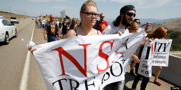 Protesters march along the roadside to the new National Security Agency (NSA) Utah Data Center being built in Bluffdale, Utah, U.S., on Thursday, July 4, 2013. Russian President Vladimir Putin said NSA whistleblower Edward Snowden must quit hurting American interests if he wants to remain in Russia, after an official said the fugitive applied for asylum there. Photographer: George Frey/Bloomberg via Getty Images